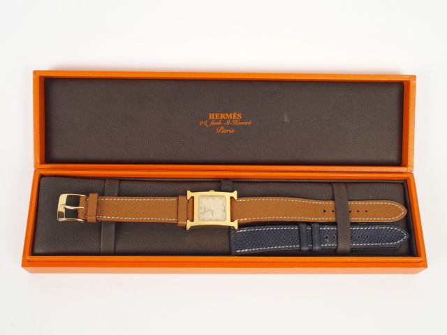 HERMES. Montre H femme, boitier or et bracelet chocolat. On y joint un