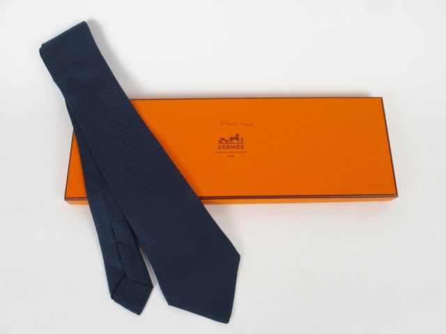 HERMES. Cravate en soie bleu marine, à décor de H