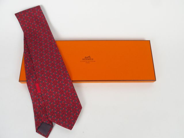 HERMES. Cravate en soie à décor stylisé rose sur fond gris