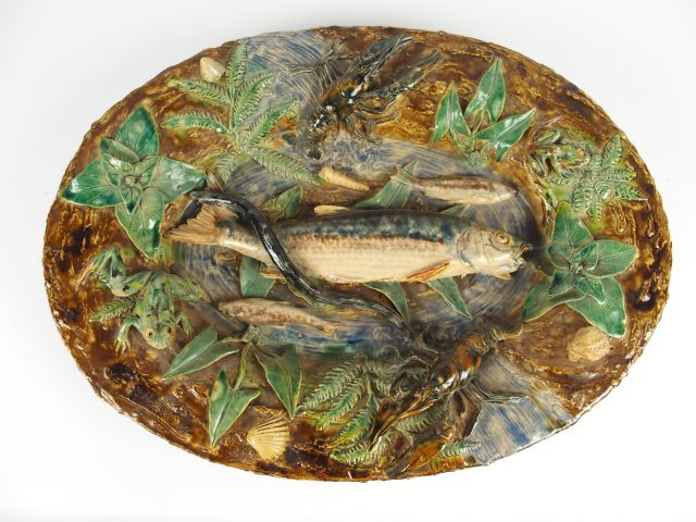 RENOLEAU. Grand plat ovale en barbotine à décor polychrome et en relie