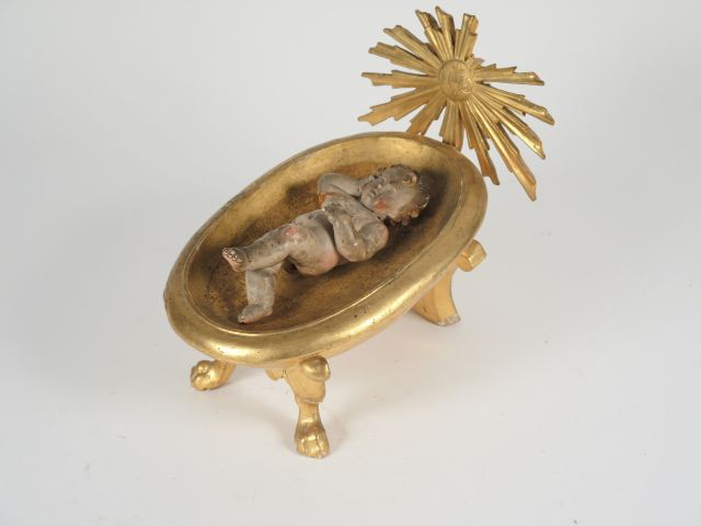 Sculpture en bois polychrome et doré figurant l’enfant Jésus dans un b