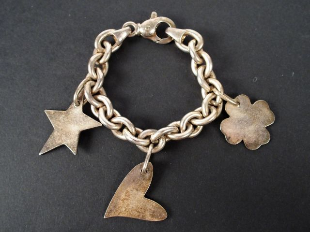 Bracelet en argent décor de 3 breloques. Poids: 63,9gr