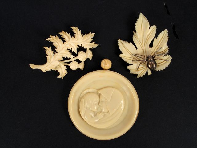 2 broches en ivoire et métal, l'une forme de fleur et feuille de chard