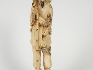 Sujet en ivoire sculpté,  'le pêcheur au bâton' sur son socle.  Chine,