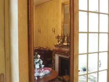 Miroir de style Louis XVI en bois sculpté et doré, à décor de perles e