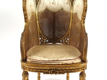 Bergère à oreilles cannée de style Louis XVI en bois sculpté et doré.