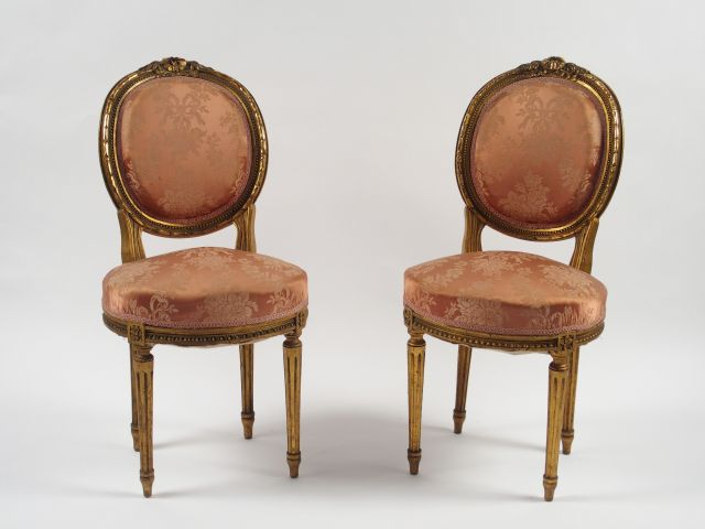 Paire de chaises de style Louis XVI en bois doré et sculpté.