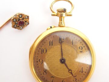 Petite montre de col en or jaune, décor de roses et de rubis. On y joi