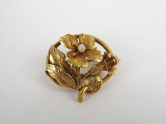 Vente aux enchères Broche en or jaune, à décor de fleur rehaussée d'une petite perle (piq