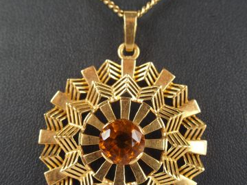Pendentif en or jaune, motifs géométriques, orné en son centre d'une c