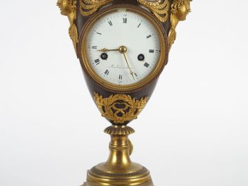 Pendule Empire en forme de vase à l'antique en bronze patiné et doré, 