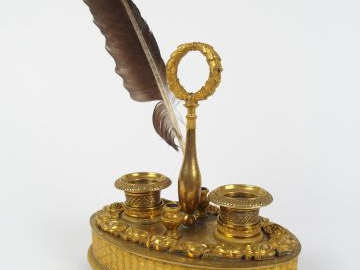 Encrier XIXe en bronze patiné à décor d'une frise de roses. Piètement 