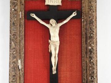 Christ en ivoire sculpté, dans un cadre Régence à décor de feuilles de