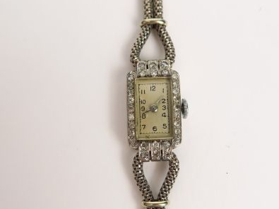Montre de dame en or gris pavée de brillants, cadran à chiffres arabes