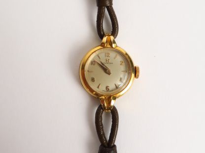 OMEGA. Montre bracelet de dame, cadran en or (à charge, voir à l'intér