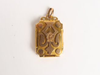 Pendentif Napoléon III en or, à décor stylisé, monogrammé. Poids avec 