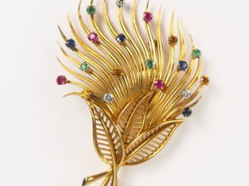 Broche feuillage en or jaune ornée de petits rubis, saphirs, émeraudes
