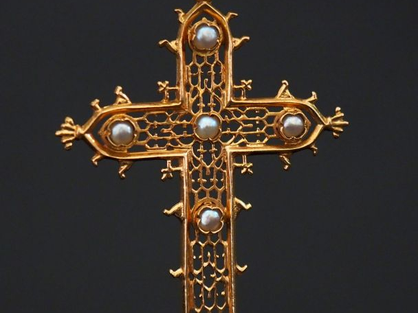 Croix en or ajouré, ornée de six perles.  Poids tel : 5,78 g   