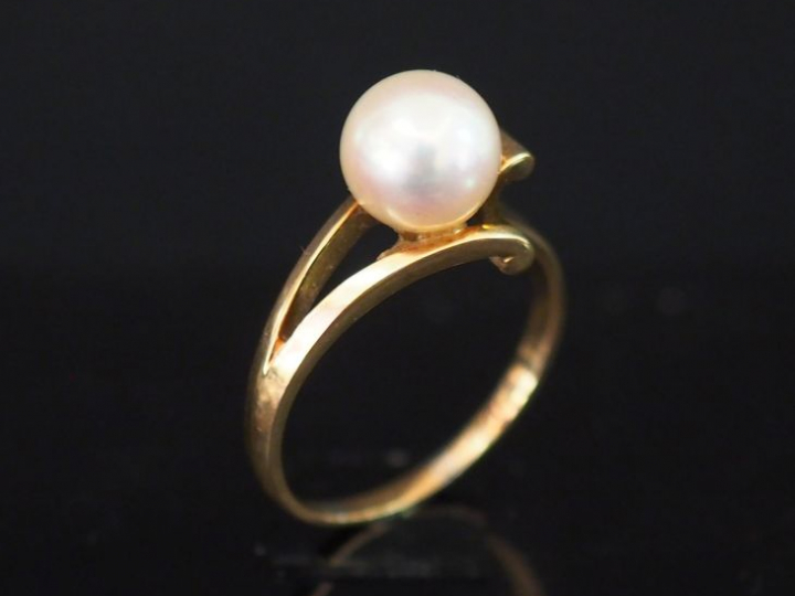 Bague de forme stylisée et ajourée en or jaune, sertie en son centre d