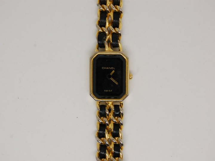 CHANEL. Montre de dame, bracelet en métal doré et cuir (usures)