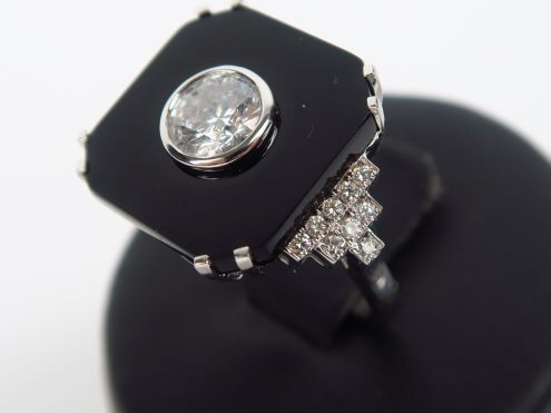 Bague en or gris, ornée d'une plaque d'onyx sertie d'un diamant de 1 c