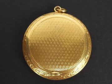 Pendentif porte photo en or jaune, décor gravé. Poids tel: 17,4gr