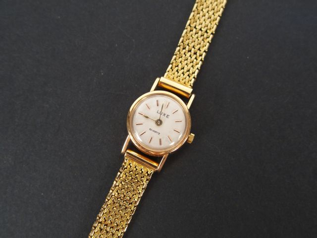 LUXE. Montre de dame, boitier rond et bracelet semi rigide en or jaune