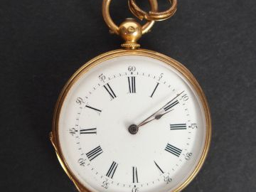 Montre de col en or jaune, cadran émail, décor de cartouche et de fris