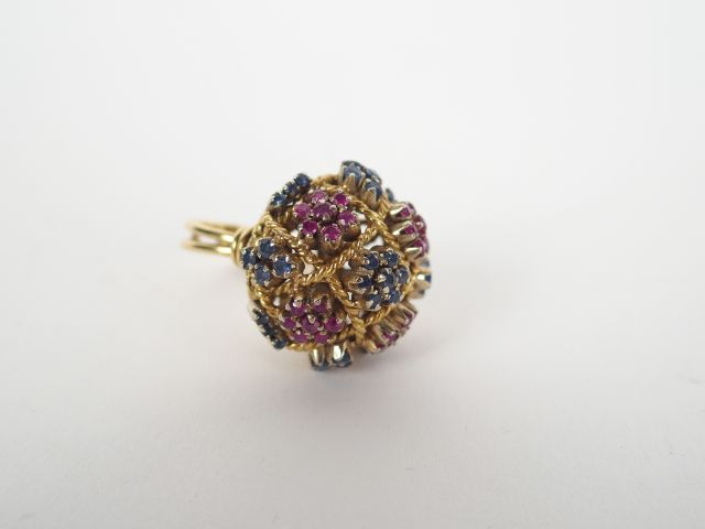 Bague dôme monture or jaune ajourée, rehaussée de saphirs et rubis.  T