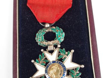 Boite en carton rouge sombre contenant une étoile de chevalier de la l