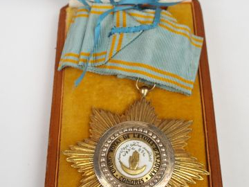 Boite en carton gainée de cuir fauve et contenant une étoile de comman