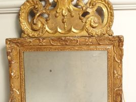 Miroir XVIII ème en bois mouluré et sculpté, à décor de rinceaux, surm