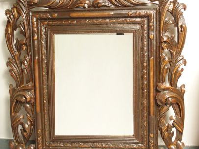 Miroir en bois mouluré et sculpté, à décor de palmettes et de feuillag