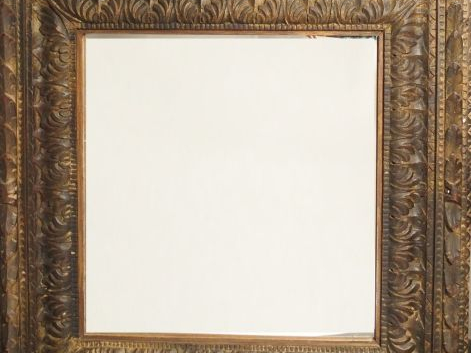 Miroir de style italien en bois sculpté et mouluré, à décor de rinceau