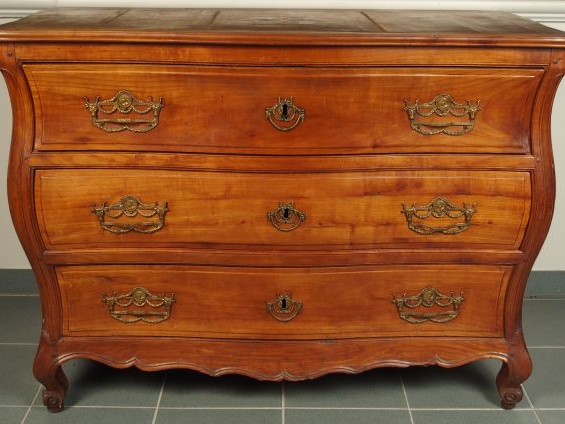 Commode XVIII ème en merisier mouluré et sculpté, ouvrant à trois tiro