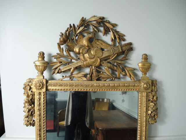 Glace Louis XVI en bois sculpté et doré, à décor de fleurs, de feuille