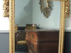 Glace Louis XVI en bois sculpté et doré, à décor de fleurs, de feuille