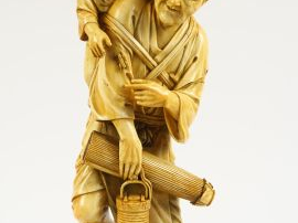 Okimono en ivoire représentant un paysan tenant une ombrelle et une la