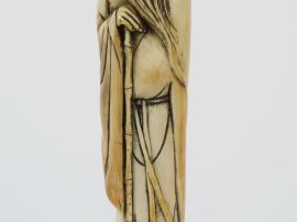 Sujet en ivoire figurant un sage les deux mains posées sur un bâton, l