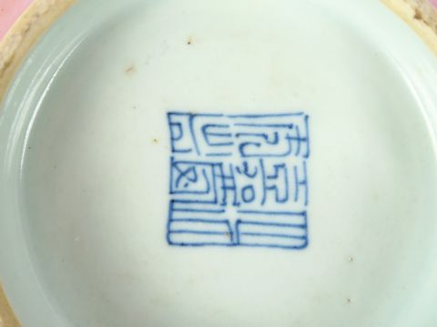 Trois pièces en porcelaine à décor stylisé rouge sur fond rose, porte 