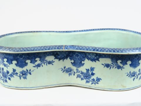 Bourdalou en porcelaine émaillée blanc bleu à décor de végétaux.  Comp