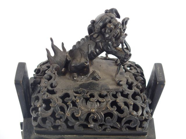 Fanding en bronze à patine brune à décor de chien de Fô. Chine XIXème.