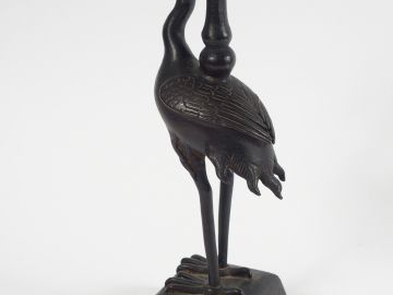 Porte-cierge en bronze à patine brune, figurant un échassier supportan