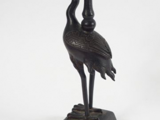 Vente aux enchères Porte-cierge en bronze à patine brune, figurant un échassier supportan