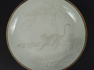 Vente aux enchères Coupe en porcelaine blanche, décor en grisaille d'un tigre en hiver.  