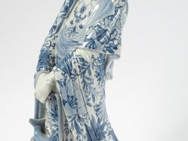 Statuette en porcelaine d'Aarita représentant une divinité tenant un p