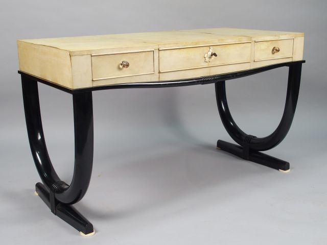 André ARBUS. Table bureau en parchemin et laque noire ouvrant à trois 