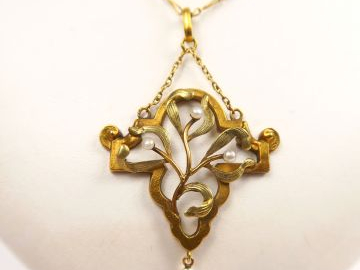 Chaine en or retenant un pendentif figurant une branche de gui agrémen