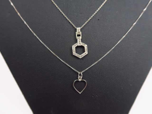 Deux chaines retenant deux pendentifs en or blanc, l'un rehaussé de pe