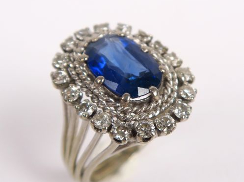 Bague ornée d'un saphir dans un entourage de petits diamants taille an